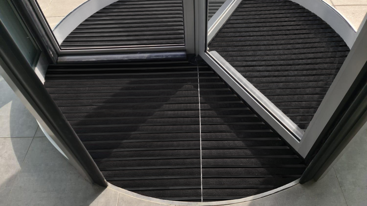 Image of Nuway Grid Black Anodised barrier matting installed in a revolving door entrance