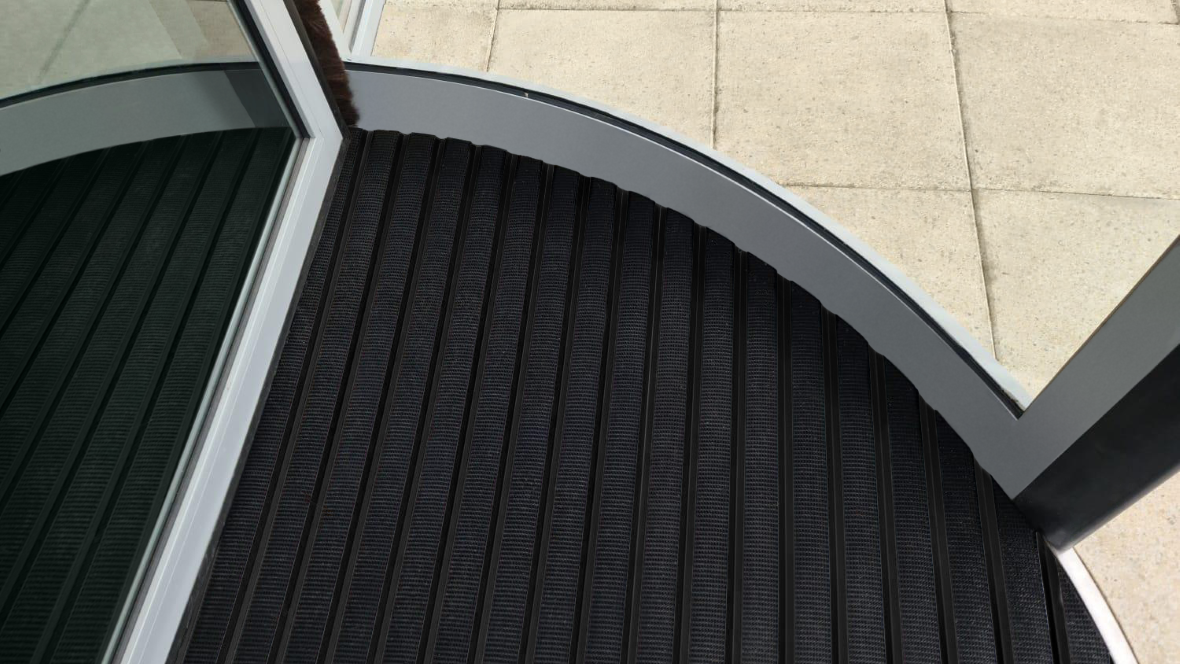Close up image of Nuway Grid Black Anodised in revolving doorway