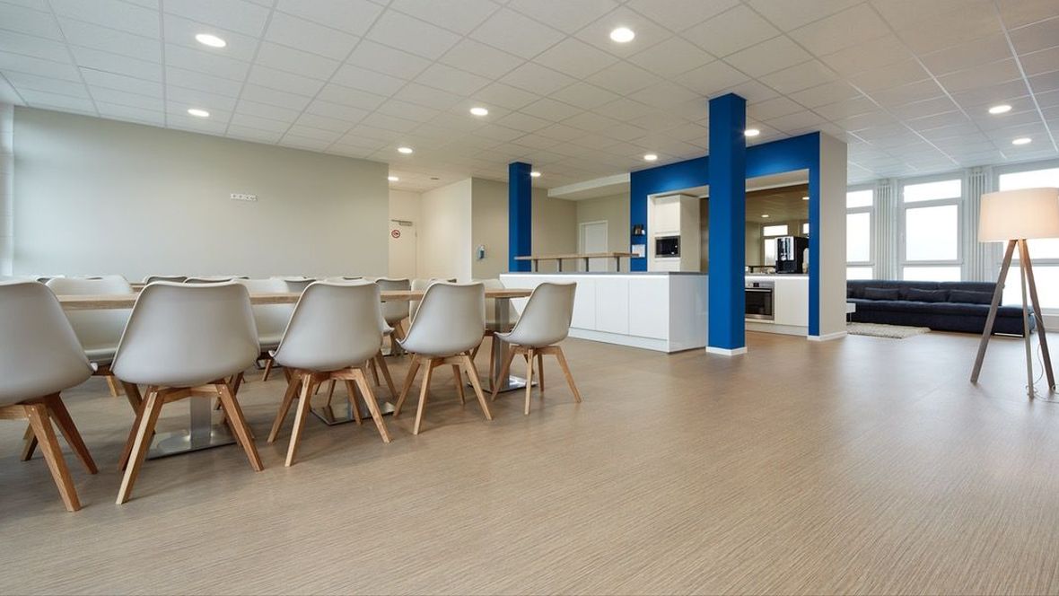 Leistungszentrum SC Paderborn 07 Tisch mit weißen Stühlen auf holzoptik Boden – Forbo Surestep Wood
