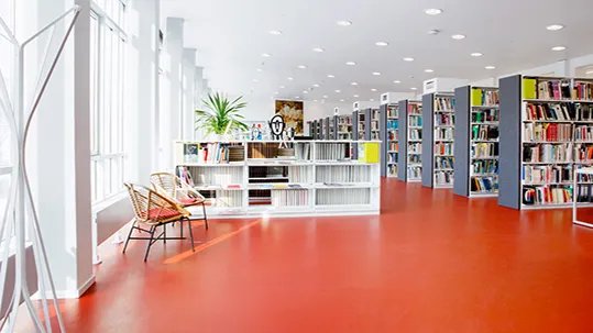 Bildungswesen: Bibliothek mit rotem Forbo Linoleum Boden.