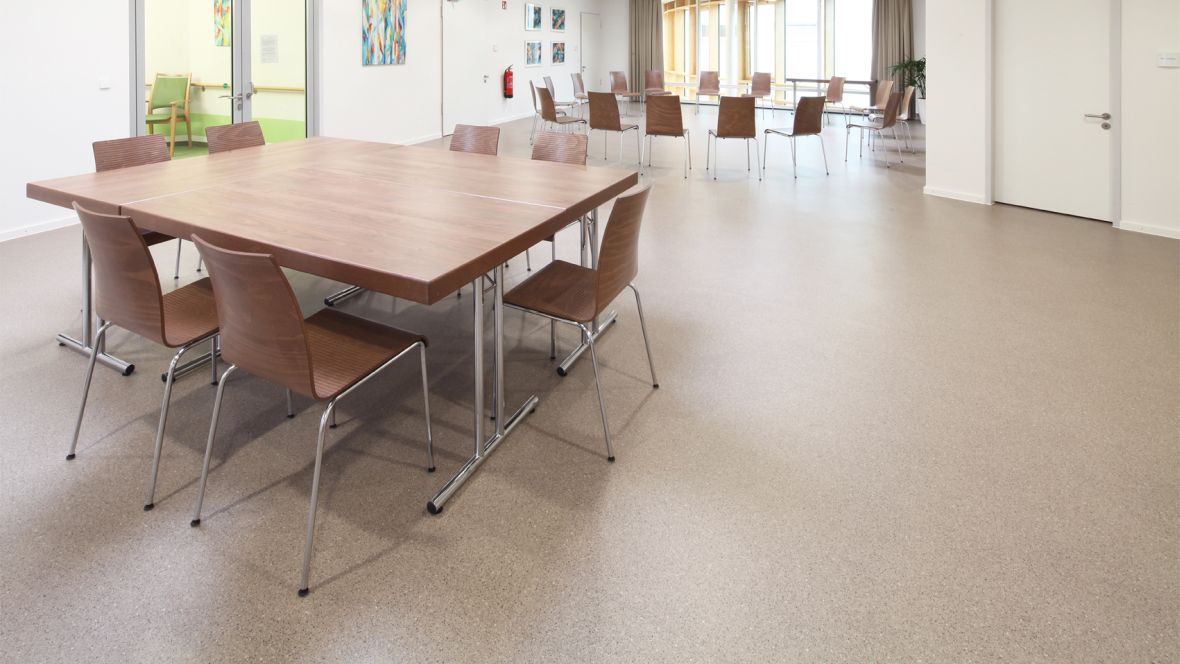 Evangelisches Pflegezentrum Baierbrunner München Tisch und Stühle auf braunem Boden – Forbo Eternal Smaragd