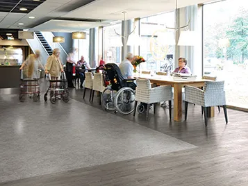Alterspflege und sozialer Wohnungsbau: Stühle und Tische in einem Altersheim mit LVT Boden (Forbo Allura Luxury Vinyl Tiles).